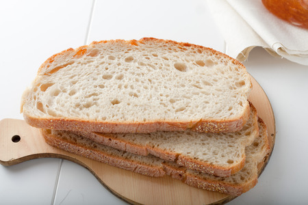 three slices of white bread on a wooden cutting board