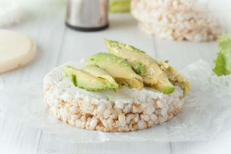 rice cake with cream cheese and avocado on white backgroundの写真素材