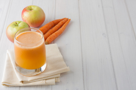 fresh homemade apple carrot juice in a glass on white backgroundの写真素材