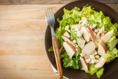 salad with apples, walnuts and cheese on wooden background, horizontal top view with room for textの写真素材
