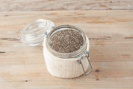 raw chia seeds in glass jar on wooden rustic backgroundの写真素材