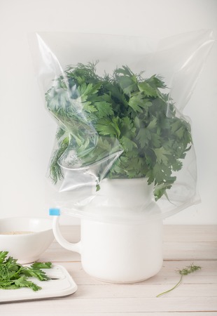 close up of properly stored fresh herbs - in water and wrapped in plastic bagの写真素材