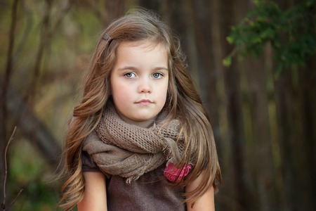 portrait of a beautiful four year old girl with long hair on a warm autumn day, horizontal imageの写真素材