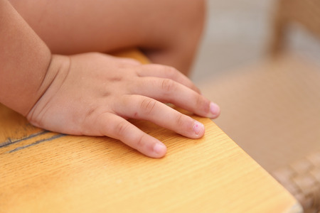 closeup of a child's hand sitting on a desk, color image, short depth of fieldの写真素材