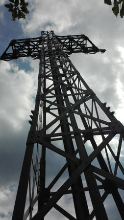 Electricity pylon with cloudy sky in the backgroundの写真素材