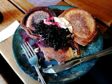 Pancakes with blueberry jam and sour cream on blue plateの写真素材