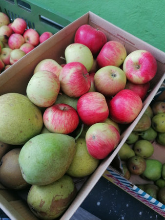 Organic apples and pears in a box at a farmers marketの写真素材