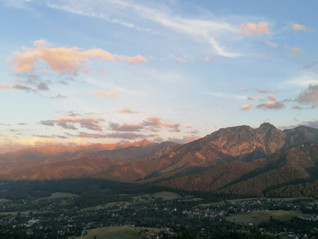 Sunset in the mountains with a view of the valley and the villageの写真素材