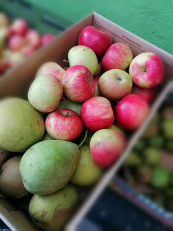 Fresh apples and pears in a box on the market. Selective focus.の写真素材