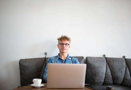 Young man proud writer of homepage working distance on laptop computer, sitting in modern coffee...