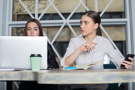 Woman intelligent marketing coordinator listening interesting training course while her partner working on laptop computer. Female professional marketer on brainstorming. Student girl learningの写真素材