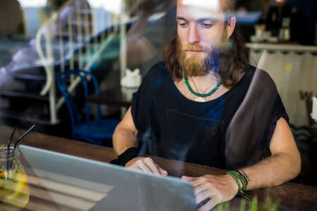 View through the window of a bearded Sweden hipster guy professional content writer for website...