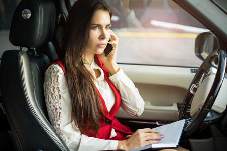 Serious woman intelligent leadership having serious mobile phone conversation while sitting in...