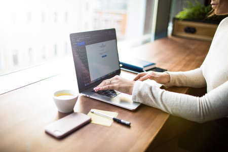 Closely business woman using applications on pc laptop computer sitting at desktop in office...