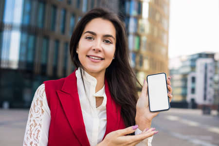 Portrait of a beautiful smiling woman professional business worker looking in camera and holding in...