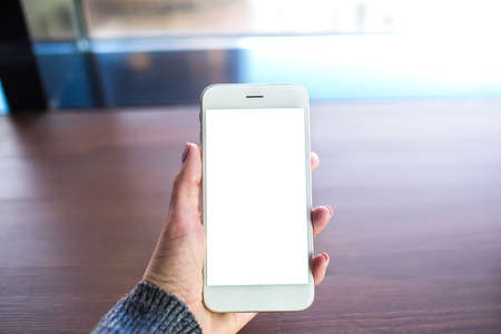 Closely business woman holding modern white smartphone with empty mockup copy space screen...