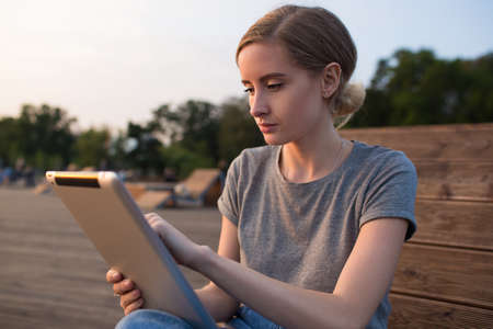 Charming hipster girl skilled freelance publication specialist searching information via portable...