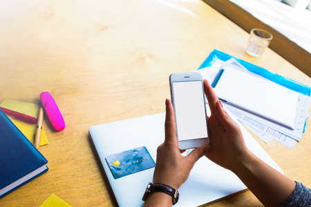 Business woman online ordering via cellphone with empty mock up copy space screen and using credit...