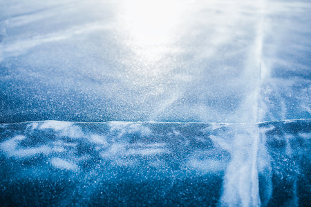 Blue transparent clear ice with deep cracks in sunny day on Baikal lake. Beautiful natural winter landmarkの写真素材