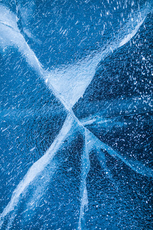 View from above on beautiful frozen Baikal lake with cracks on the transparent ice surface background for adverting contentの写真素材