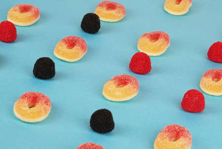 Delicious fruity gummy sweets jelly beans candies on pastel blue trendy backgroundの写真素材
