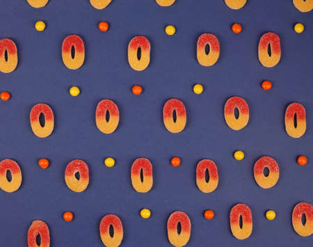 Delicious fruity gummy sweets jelly beans candies on blue trendy background