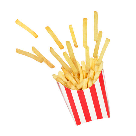 Perfect french fries potato pieces flying around in red white striped box. Creative food concept...
