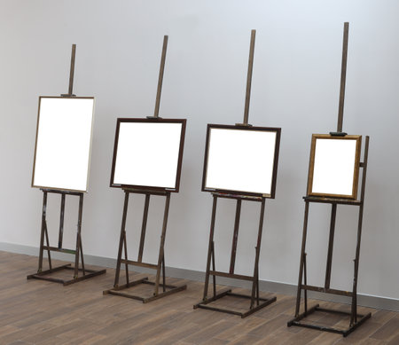 Four frames on easel exhibition empty gallery museum on white wall. Space for art pictures paintings. Interior creative atelier conceptの写真素材
