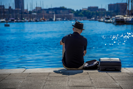 Man resting on the edge of promenade at the Vieux port old port in Marseille, Franceの写真素材