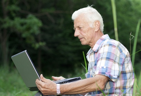 An elderly man with a laptopの写真素材