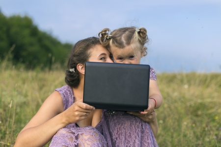 mother and child at a laptop on the natureの写真素材