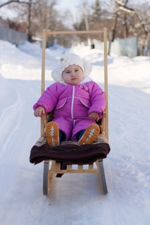 little girl on a sled in the winterの写真素材