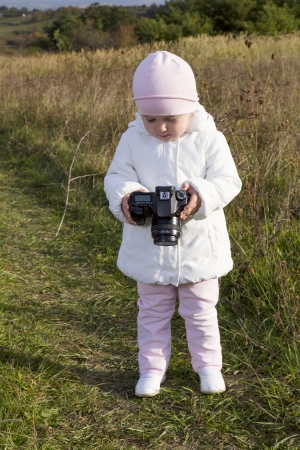 little baby on nature with a cameraの写真素材