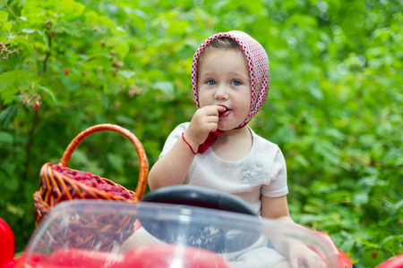 girl on the car and with a raspberry in natureの写真素材
