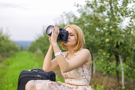Girl photographing the surrounding landscapeの写真素材