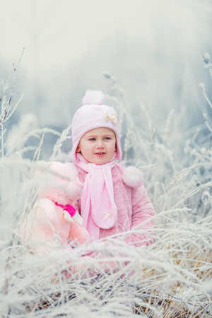 little girl near a forest in winterの写真素材