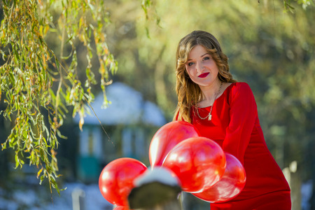 The girl in the red dress on nature with ballsの写真素材