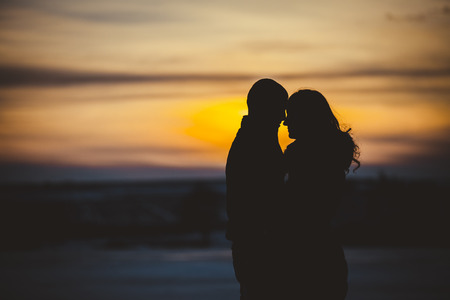 boy and girl in winter at sunsetの写真素材