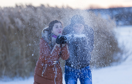 frozen girl with a guy blow away the snowの写真素材