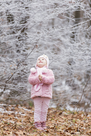 little girl near a forest in winterの写真素材