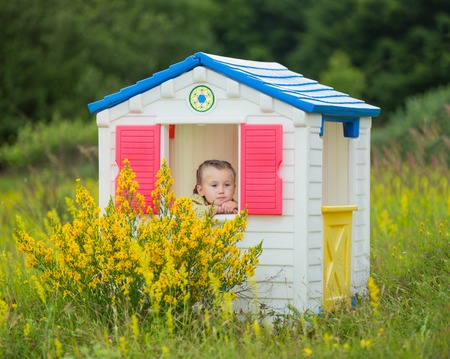 little girl sitting in a toy houseの写真素材