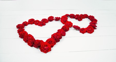 Heart shape of roses on a white tableの写真素材