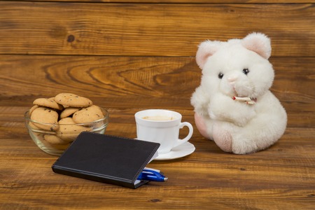teddy bear, coffee and cookies on the wooden tableの写真素材
