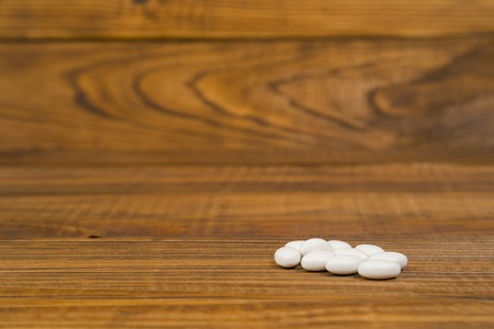 white pills closeup on a wooden tableの写真素材