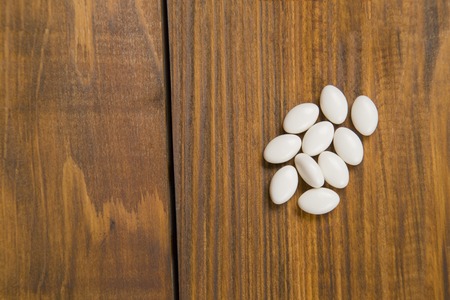 white pills closeup on a wooden table