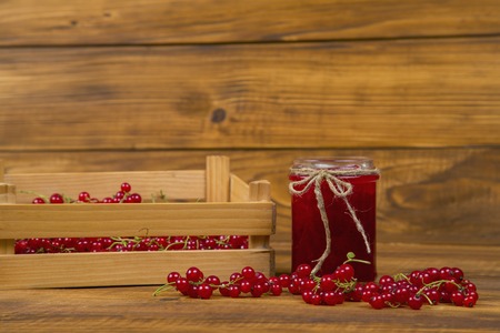 Preserves of red currants on a wooden tableの写真素材