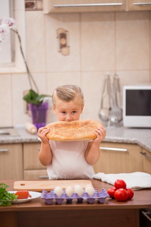 child with a loaf of bread in his handの写真素材