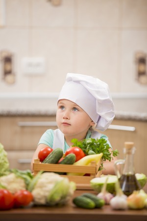 child cook with vegetables in the kitchenの写真素材