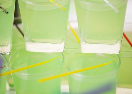 glasses with green liquid close-up as backgroundの写真素材