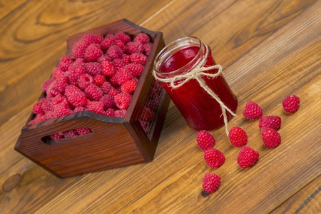 raspberries and raspberry jam on a wooden tableの写真素材